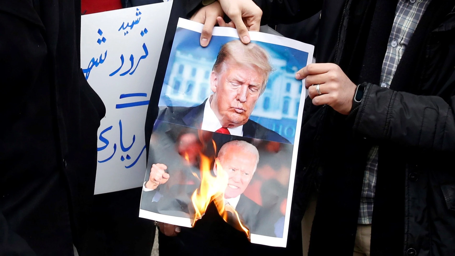 Varios estudiantes iraníes queman una foto del presidente de Estados Unidos, Donald Trump, y el presidente electo, Joe Biden
