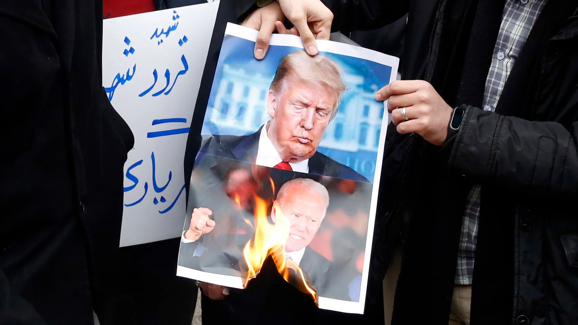 Estudiantes queman en Teherán una foto de Donald Trump y Joe Biden tras el asesinato del científico nuclear Mohsen Fakhrizadeh