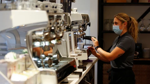 Una camarera sirviendo café en un bar de Granada