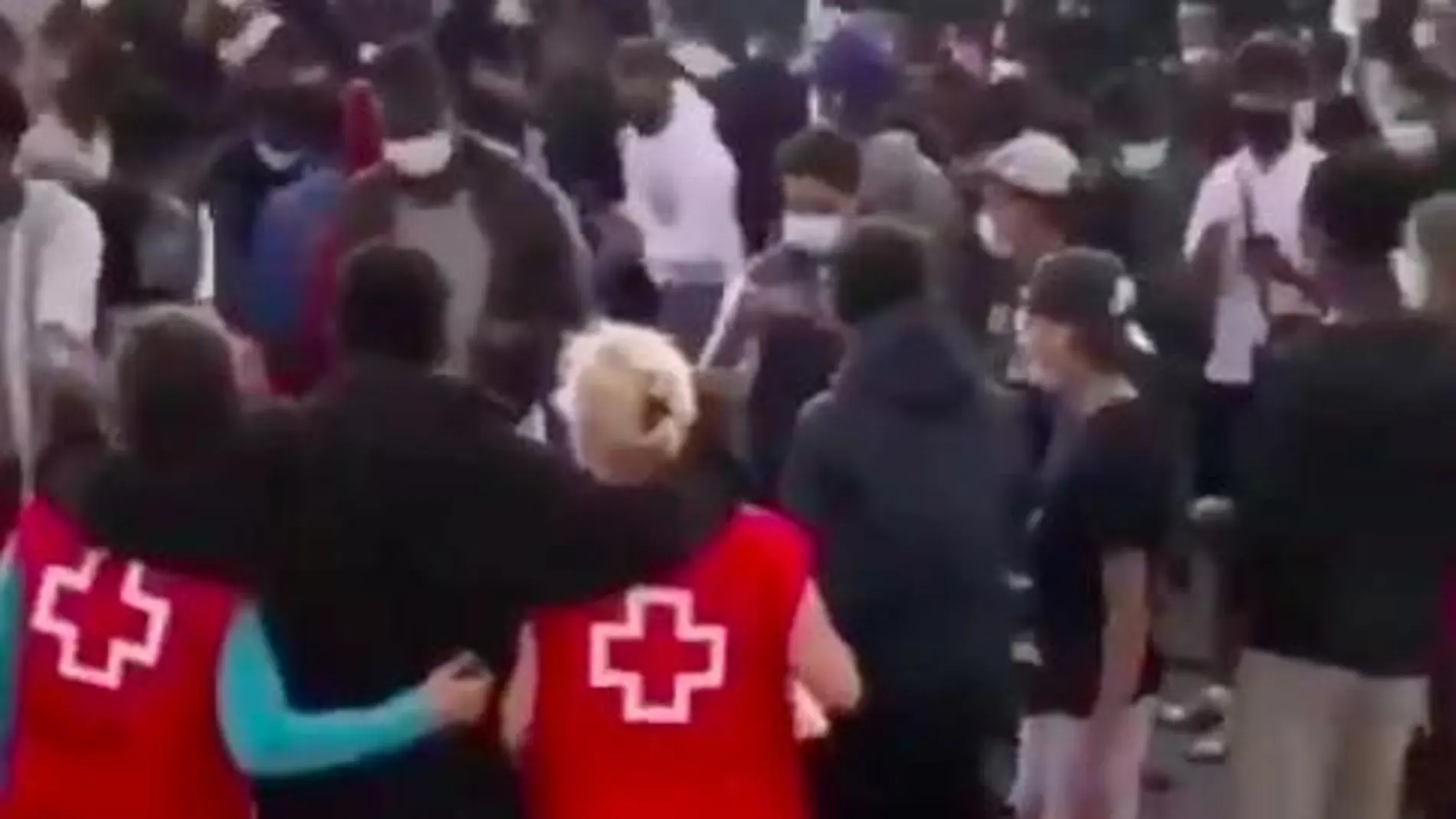 Fotograma del vídeo en el que se ven a inmigrantes bailando con miembros de Cruz Roja