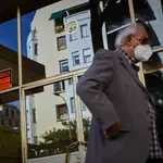 Un hombre pasa por delante de un cartel de una vivienda en alquiler