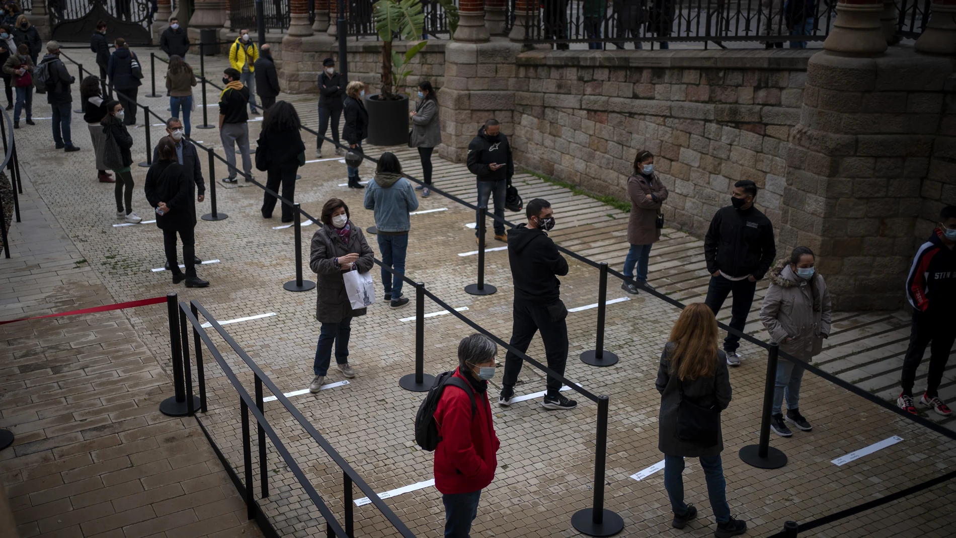 Un grupo de personas espera para realizarse un test en un hospital de Barcelona
