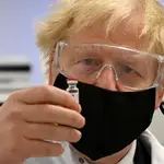 Boris Johnson posa con un vial de la vacuna AstraZeneca/Oxford University COVID-19 ayer en Gales.