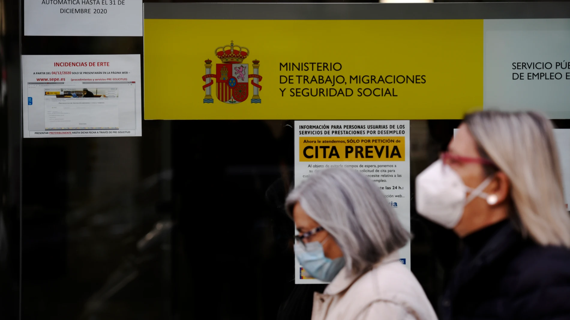 Dos mujeres pasan por la puerta de una oficina de empleo