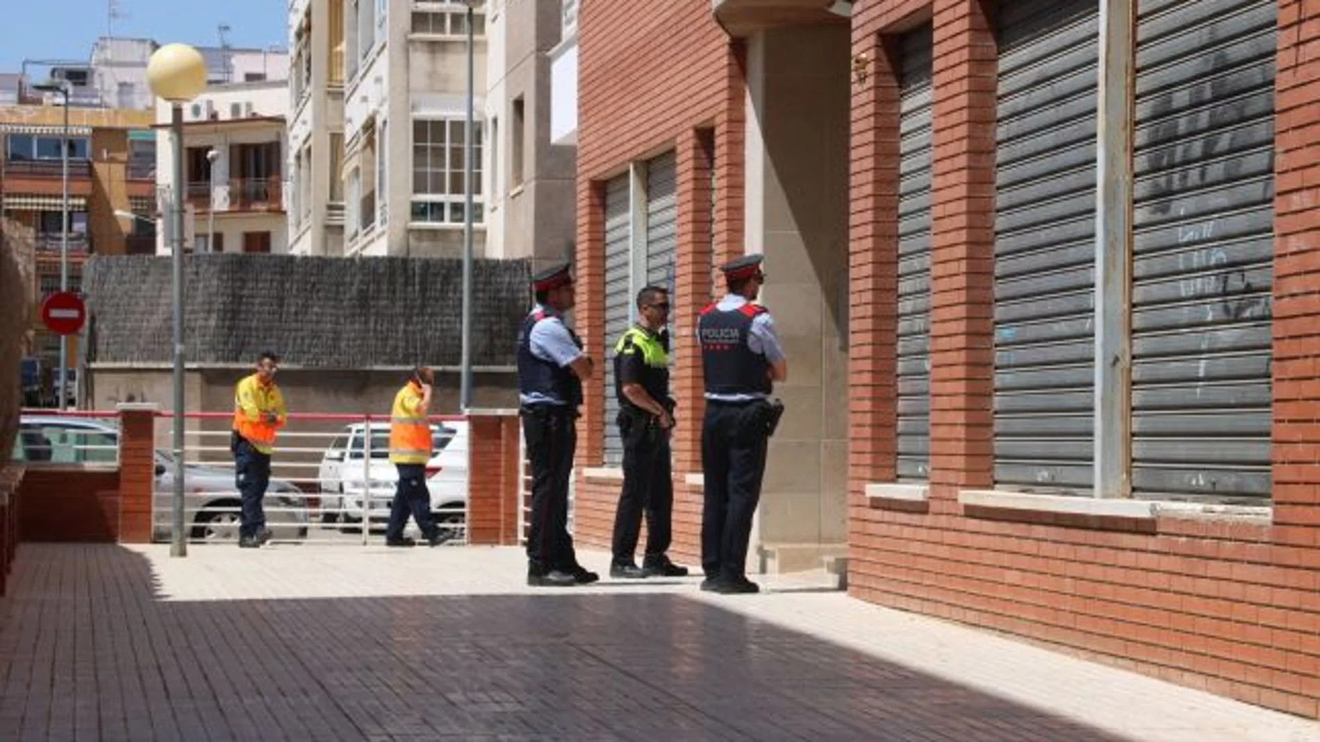Agentes de los Mossos, ante el edificio donde ocurrió el incendio y el asesinato