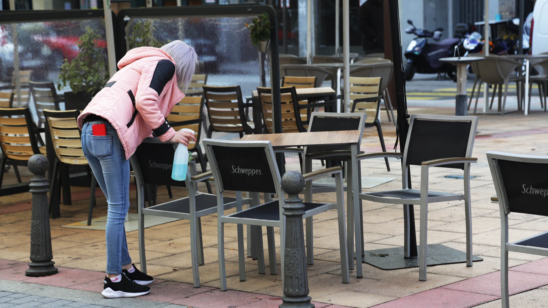 Una camarera desinfecta una mesa en León,