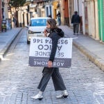 Una mujer con un cartel de compra venta de vivienda por los alrededores de la Catedral de Sevilla. Eduardo Briones / Europa Press