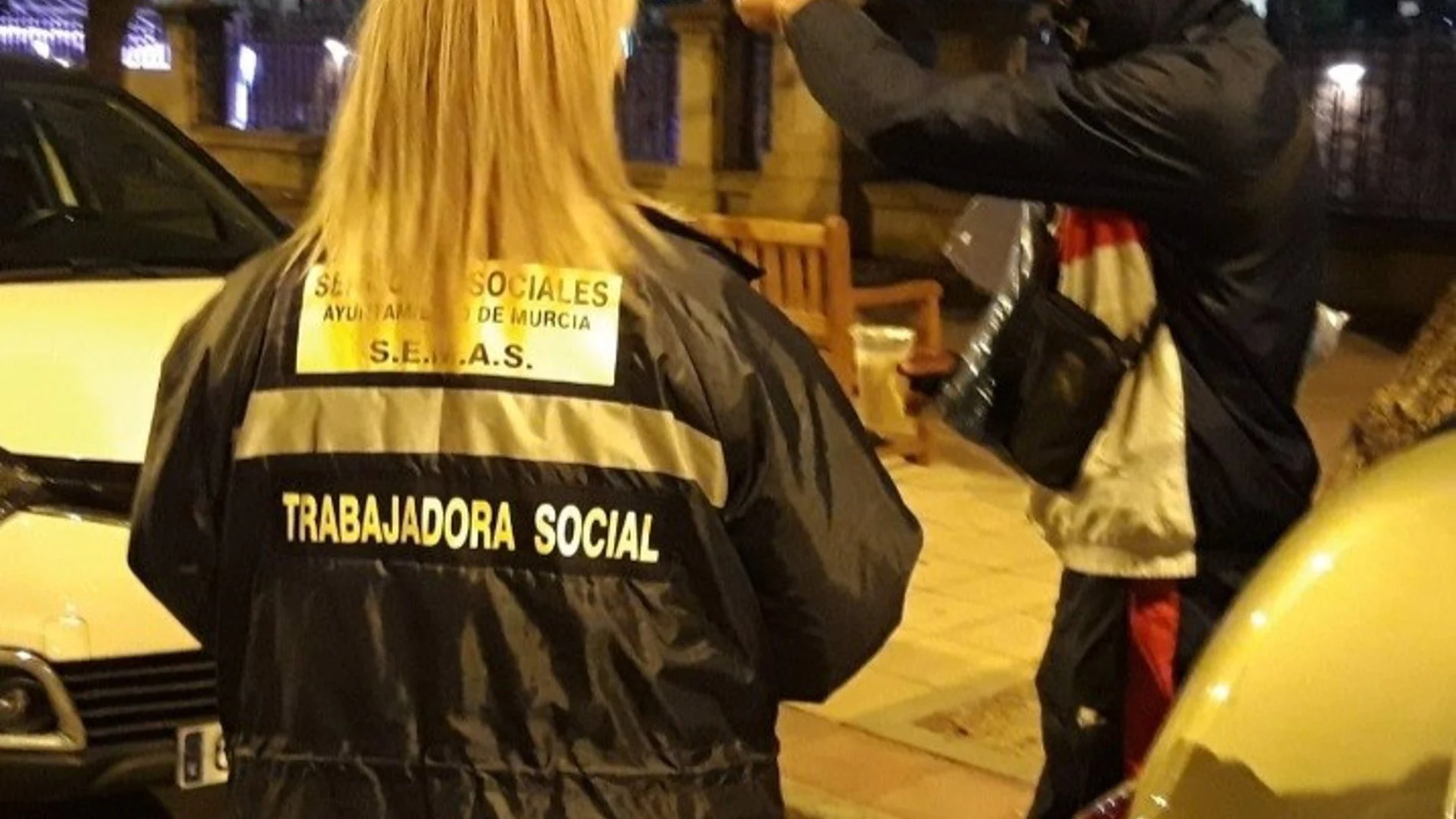 Una trabajadora social habla con un sin techo en Murcia