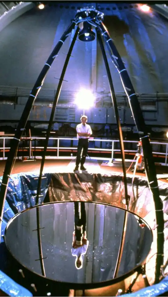 Una imagen del segundo prototipo de telescopio con espejo líquido, el Liquid Mirror Telescope de la NASA. Estuvo en funcionamiento entre los años 1995 y 2002, tenía un espejo de tres metros de diámetro y se utilizó para monitorizar basura espacial. La luz entra por la parte superior, se refleja en el espejo y es dirigida al sensor, que es el dispositivo montado arriba, sobre las patas de araña.