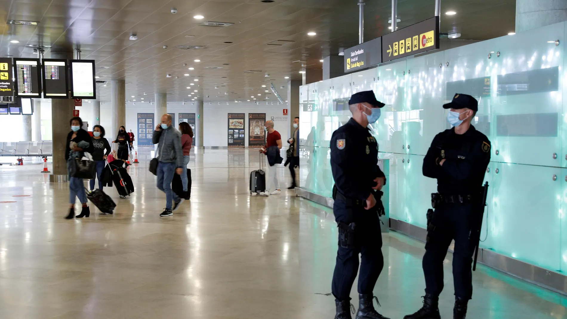 Dos agentes de la Policía Nacional vigilan la puerta de llegadas del aeropuerto de València