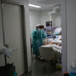 Personal sanitario visita a un enfermo ingresado en la Unidad de Cuidados Intensivos –UCI- del Hospital de la Santa Creu i Sant Pau, en Barcelona. David Zorrakino / Europa Press