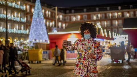 Un hombre con mascarilla se hace una foto en la Plaza Mayor