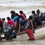 Migrantes venezolanos, deportados recientemente, llegan a la costa después de su regreso a la isla en Erin, Trinidad y Tobago