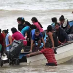 Migrantes venezolanos, deportados recientemente, llegan a la costa después de su regreso a la isla en Erin, Trinidad y Tobago