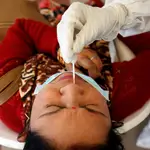 Un sanitario realiza una tes de antígenos a una mujer en Ahmedabad (India)