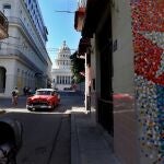 AME5411. LA HABANA (CUBA), 16/12/2020.- Un vehículo clásico y varios peatones pasan hoy por una calle con murales de la bandera cubana, junto al Capitolio en La Habana (Cuba). EFE/ Ernesto Mastrascusa