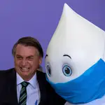 El presidente de Brasil, Jair Bolsonaro (i), posa para fotos junto a la mascota Zé Gotinha, personaje tradicional en Brasil creado para crear consciencia sobre las vacunas