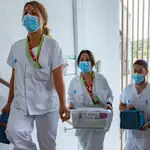Tres profesionales sanitarios trasladan la vacuna de Janssen desde el laboratorio a la sala en donde se administra a los voluntarios participantes en la administración de la vacuna contra la Covid-19 de la compañía Janssen (Johnson &amp; Johnson), en el marco del ensayo clínico Ensemble 2, el primero en Fase III que se hace en España