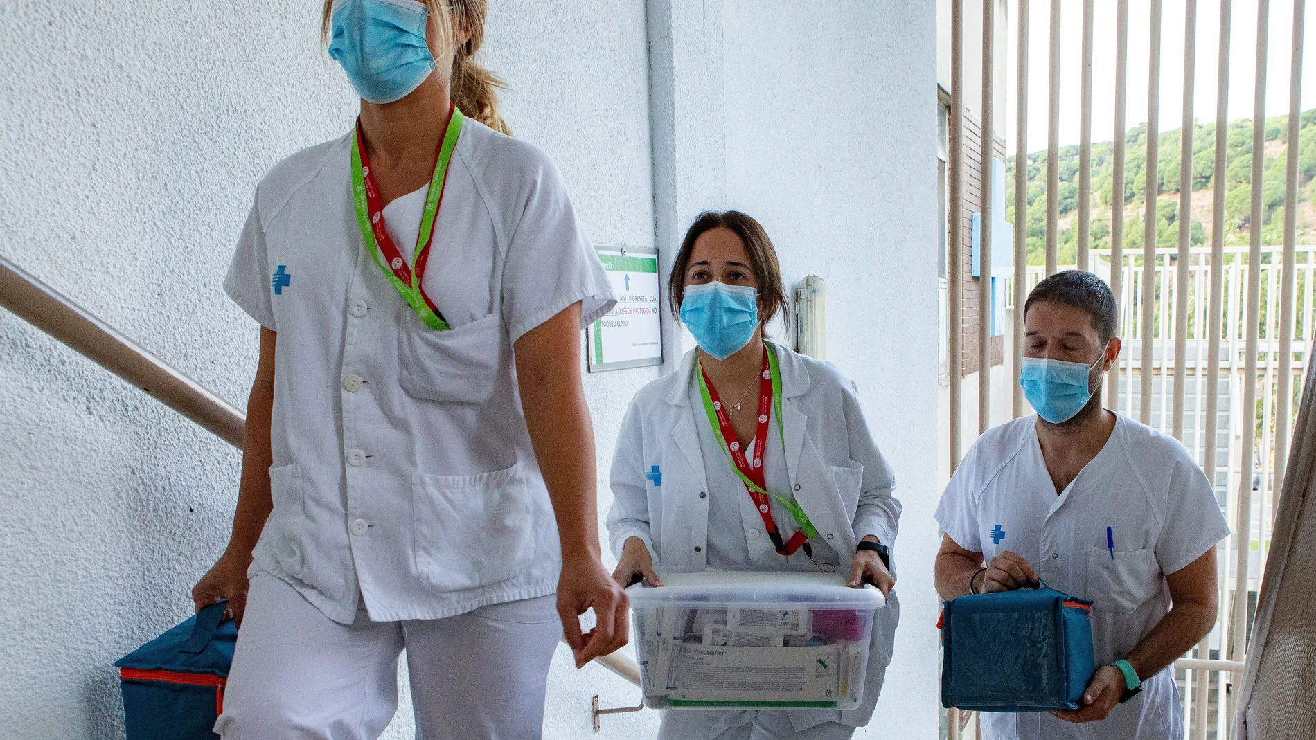 Tres profesionales sanitarios trasladan la vacuna de Janssen desde el laboratorio a la sala en donde se administra a los voluntarios participantes en la administración de la vacuna contra la Covid-19 de la compañía Janssen (Johnson & Johnson), en el marco del ensayo clínico Ensemble 2, el primero en Fase III que se hace en España