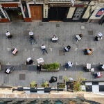 Trabajadores de la hostelería del barrio de Russafa realizan una sentada para impedir la prohibición de las terrazas, en Valencia, Comunidad Valenciana (España), a 17 de diciembre de 2020. Los hosteleros protestan por la aplicación municipal de la ordenanza de ocupación de terrazas en la vía pública, que supone una reducción drástica en lugares en los que las mesas exteriores son básicas. La sentada coincide con la llegada de los técnicos municipales para delimitar los nuevos espacios para cada bar, cafetería o restaurante.