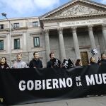 Manifestantes con máscaras de Dalí se concentran con pancartas con el símbolo de la muerte frente al Congreso de los Diputados, en Madrid