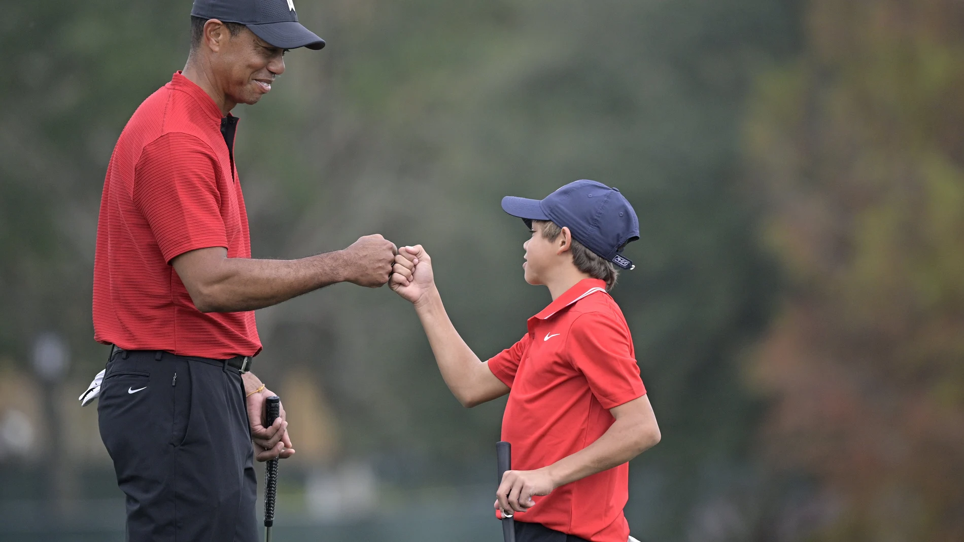 Tiger Woods y su hijo Charlie chocan los puños tras terminar su recorrido