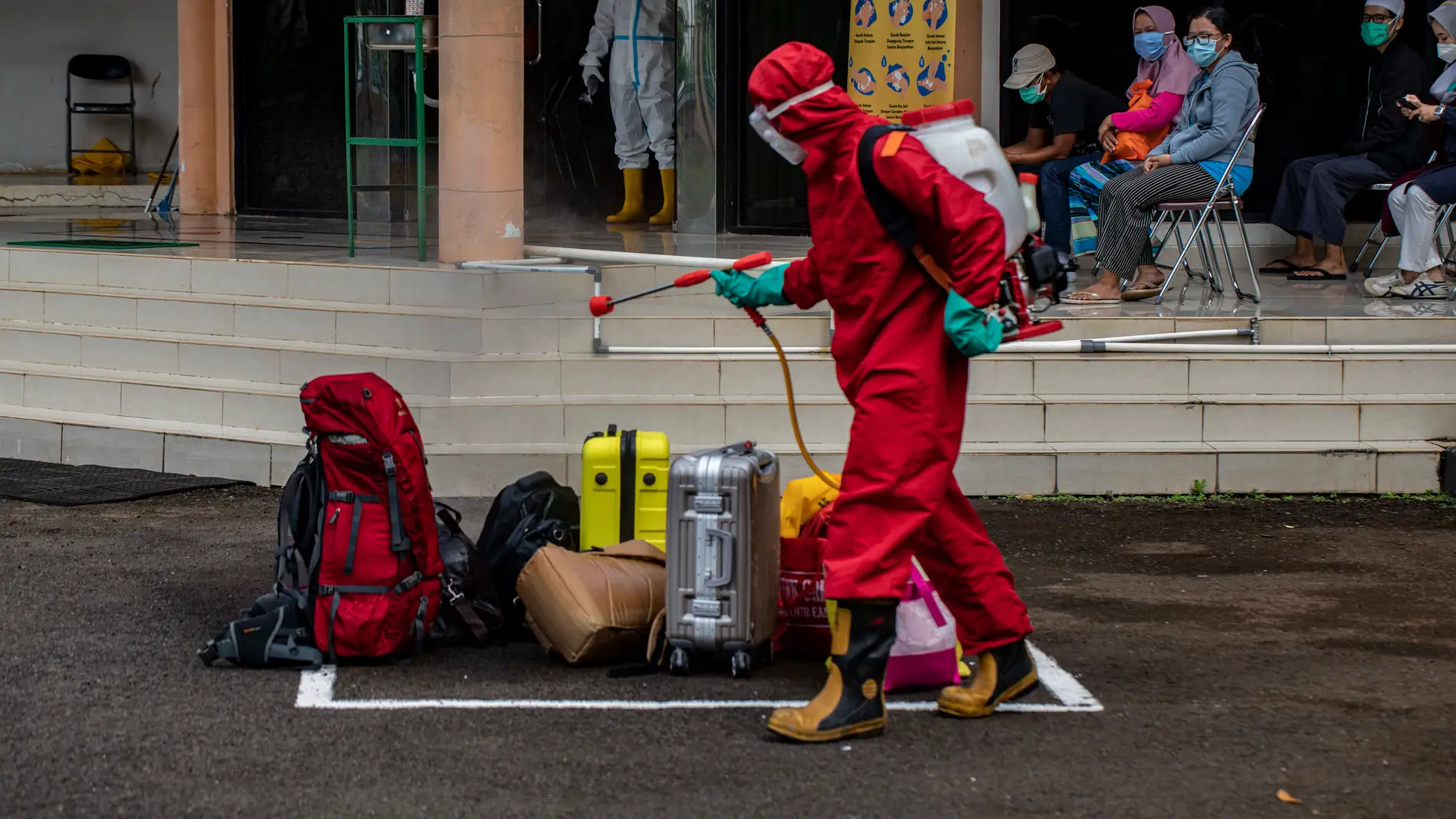 21 December 2020, Indonesia, South Jakarta: An officer spray disinfectant on the luggage of the coronavirus (COVID-19) patients upon arrival at Graha Wisata Ragunan Lodging. Photo: Donal Husni/ZUMA Wire/dpa21/12/2020 ONLY FOR USE IN SPAIN