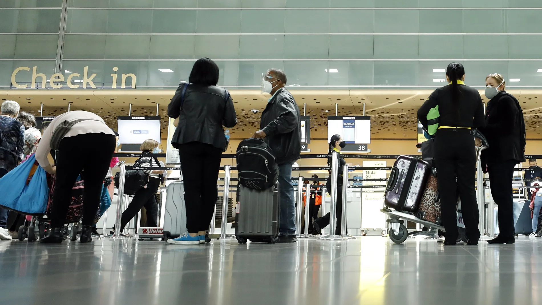 AME6117. BOGOTÁ (COLOMBIA), 21/12/2020.- Viajeros llegan al Aeropuerto El Dorado, hoy en Bogotá (Colombia). Las autoridades de distintas ciudades y regiones colombianas imponen medidas restrictivas a la circulación de personas en vísperas de la Navidad ante el preocupante avance de la pandemia de coronavirus en el país. EFE/ Mauricio Dueñas Castañeda