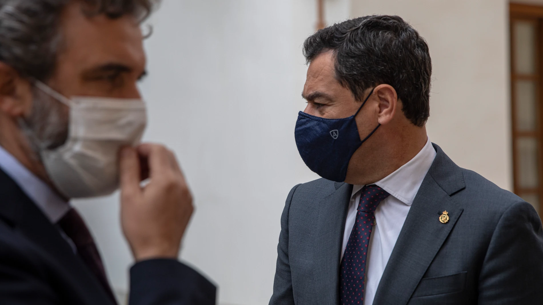 El presidente de la Junta de Andalucía, Juanma Moreno, al fondo