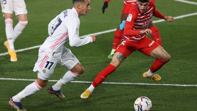 El delantero del Real Madrid Lucas Vázquez (i) intenta superar a Carlos Neva, del Granada CF en el partido de La Liga