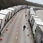 People walk amid lines of lorries queueing at the M20 motorway near Ashford amid the coronavirus disease (COVID-19) outbreak, Britain, December 26, 2020. REUTERS/Peter Nicholls