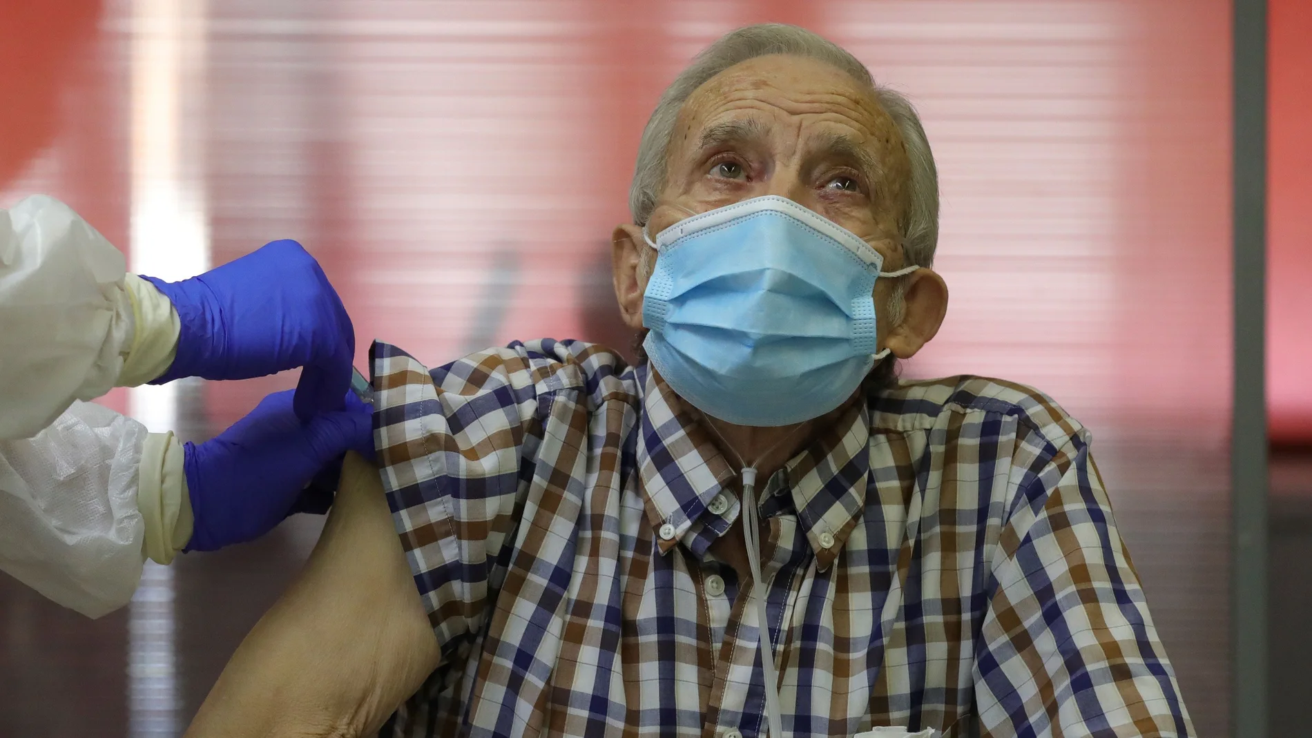 -FOTODELDIA- MADRID, 27/12/2020.- Nicanor, de 72 años, es el primer residente en recibir una dosis de la vacuna contra la covid-19 en la capital, este domingo en la residencia de mayores Vallecas de Madrid. La Comunidad de Madrid inicia este domingo la campaña de vacunación contra el coronavirus con 1.200 dosis que serán administradas en tres residencias de personas mayores de la capital, justo un día después de notificar los primeros casos de la nueva variante británica del virus en España. EFE/JuanJo Martín