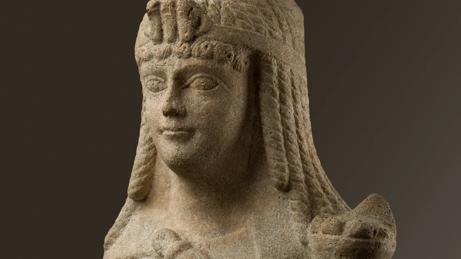 Escultura de mármol de estilo egipcio presumiblemente representando a Cleopatra VII con la corona egipcia del triple uraeus (las tres cobras que representaban los reinos bajo el dominio de la reina) y el característico vestido con el “nudo de Isis”