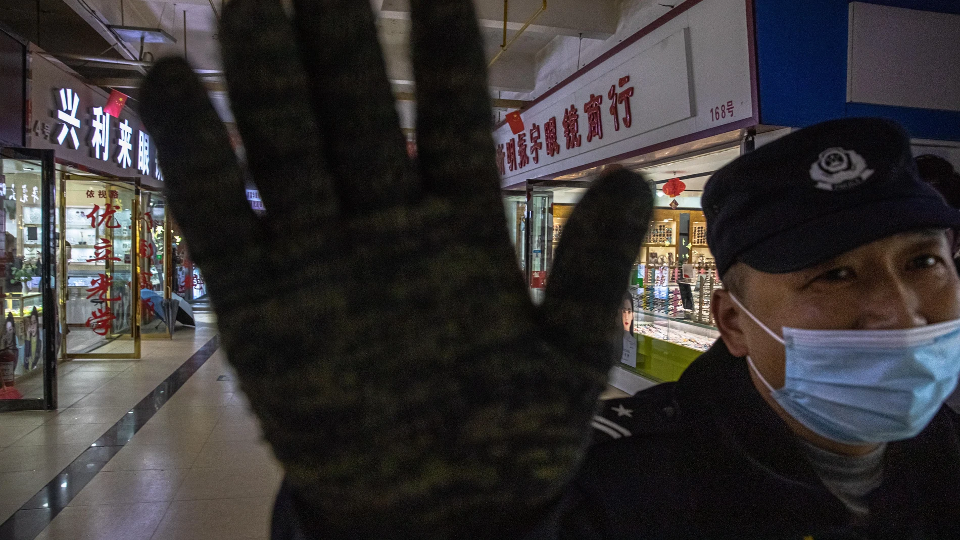 Un agente impide entrar en el mercado de Huanan, en Wuhan, una ciudad de 11 millones de habitantes epicentro de la covid-19