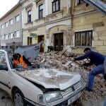 Petrinja (Croatia), 29/12/2020.- People and soldiers clean the rubble next to car and buildings damaged in an earthquake in Petrinja, Croatia, 29 December 2020. A 6.4 magnitude earthquake struck around 3km west south west of the town with reports of many injuries and at least one death. (Terremoto/sismo, Croacia) EFE/EPA/ANTONIO BAT