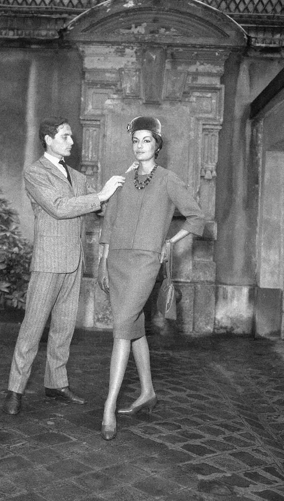 FILE - In this Sept.13, 1960 file photo, Parisian designer Pierre Cardin, with one of his models, shows the new uniform he has created for the hostesses of French television in Paris. France's Academy of Fine Arts says famed fashion designer Pierre Cardin has died at 98 (AP Photo/Pierre Godot, File)