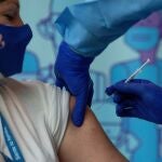 Susana, de 41 años, directora del Centro de la tercera edad Ballesol de Badalona (Barcelona), recibiendo la vacuna Pfizer contra el coronavirus.