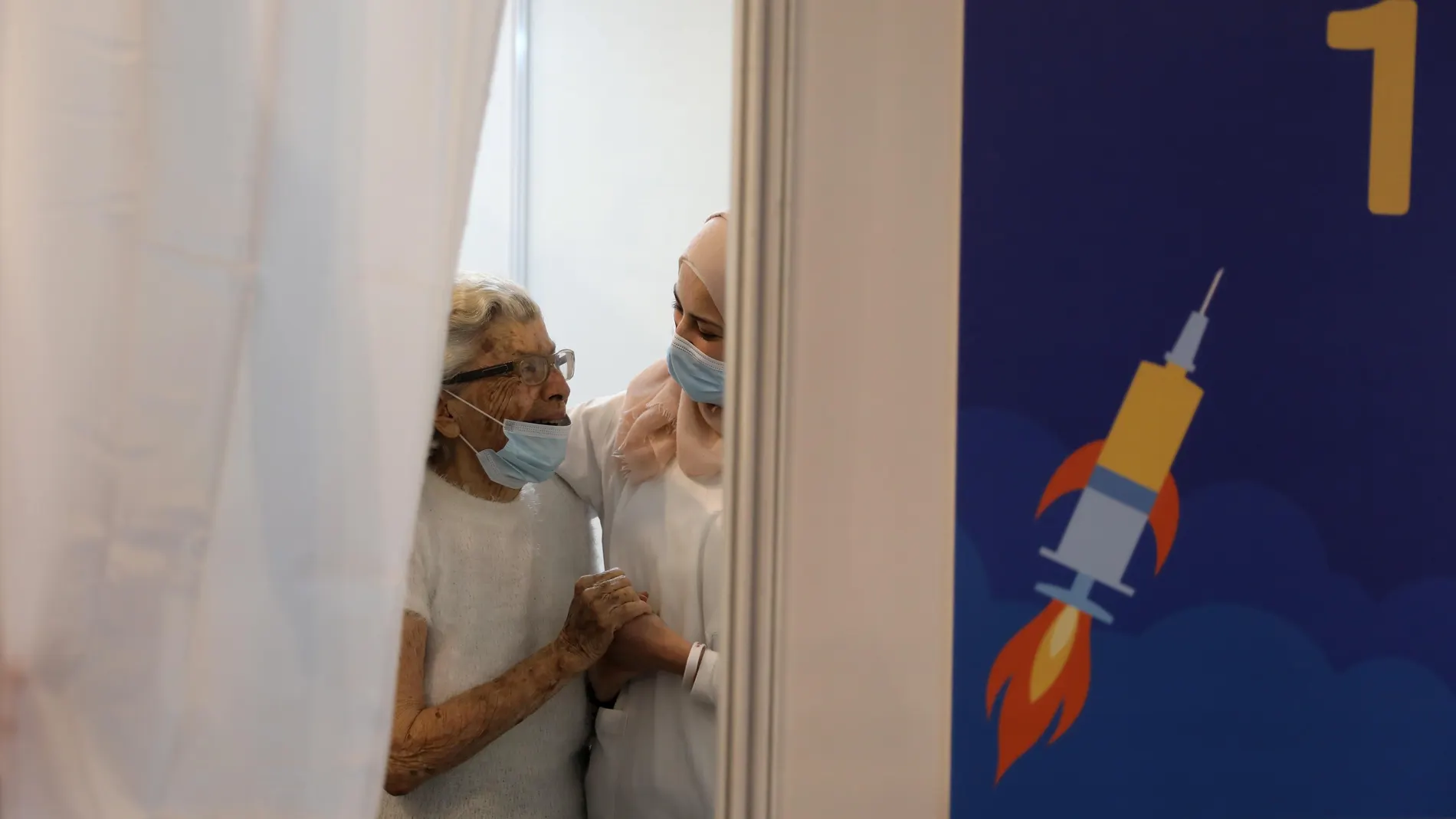 Una anciana abraza a una enfermera israelí tras recibir la vacuna contra el coronavirus en el nuevo centro de vacunaciones municipales de Tel Aviv