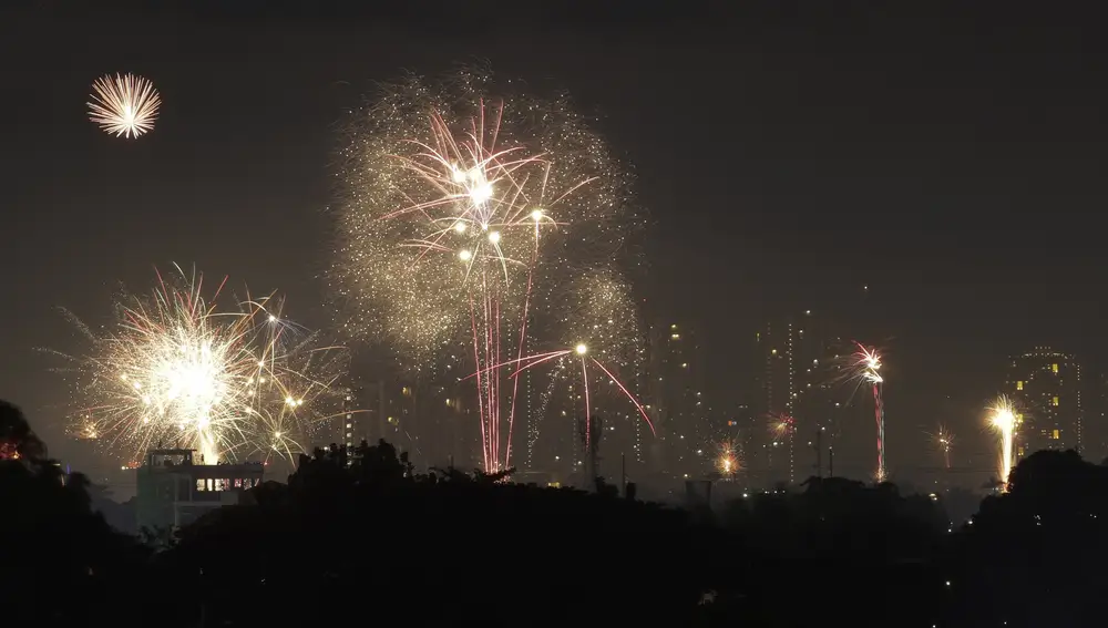 Fireworks light up the sky during subdued New Year's celebrations as the government banned mass gatherings to prevent the spread of the coronavirus, early Friday, Jan. 1, 2021, in Quezon city, Philippines. (AP Photo/Aaron Favila)
