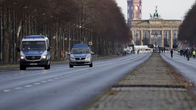 Dos coches circulan cerca de la Puerta de Brandenburgo. Toda la zona permanece cortada para evitar celebraciones por el find e año.