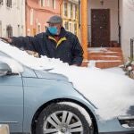 Un vecino del Calar de la Santa, pedania de Moratalla, (Murcia), retira la nieve del parabrisas de su vehículo tras la nevada del pasado mes de enero