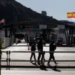 Pedestrians walk past the border between Spain and Gibraltar