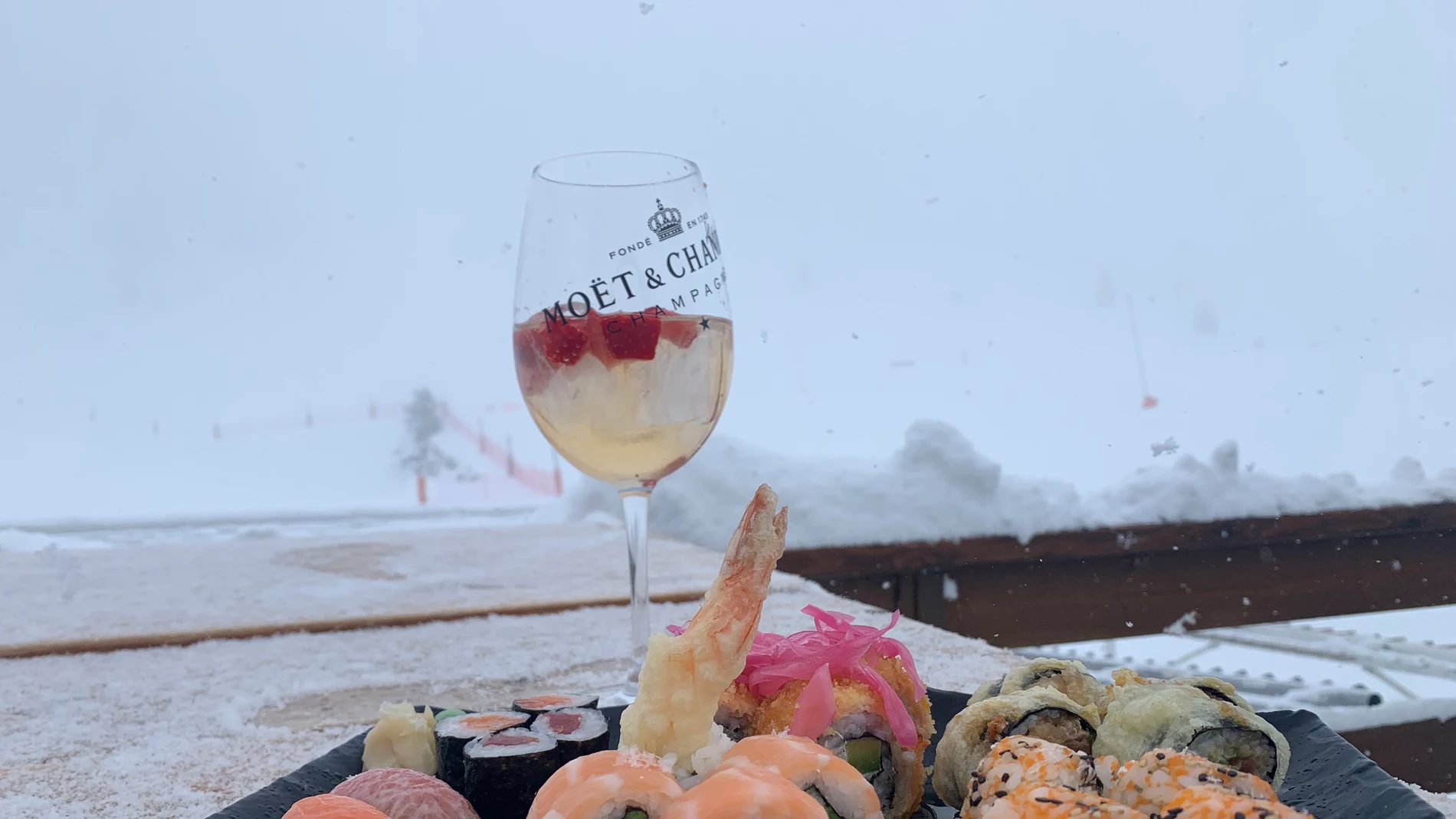 Una copa de Moët Chandon Ice Impèrial, con vistas a la nieve, y el surtido de shushis, maki roll y nigiris