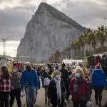 Backdropped by the Gibraltar rock, people walk along the stalls of a weekly market at the Spanish city of La Linea on Monday, Jan. 4, 2021. Fears of disruptions following Britain&#39;s departure from the European Union were replaced by coronavirus-related restrictions on border traffic between Spain and Gibraltar on Monday, the first working day at the United Kingdom&#39;s only land border with the European mainland. (AP Photo/Emilio Morenatti)