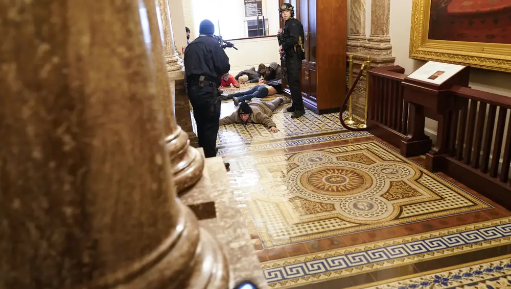 La policía del Capitolio de EE.UU. mantiene a los manifestantes a punta de pistola (AP Photo/Andrew Harnik)