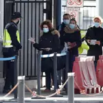 Un grupo de españoles que trabajan en Gibraltar enseñan su pasaporte a la Policía Nacional para entrar en España