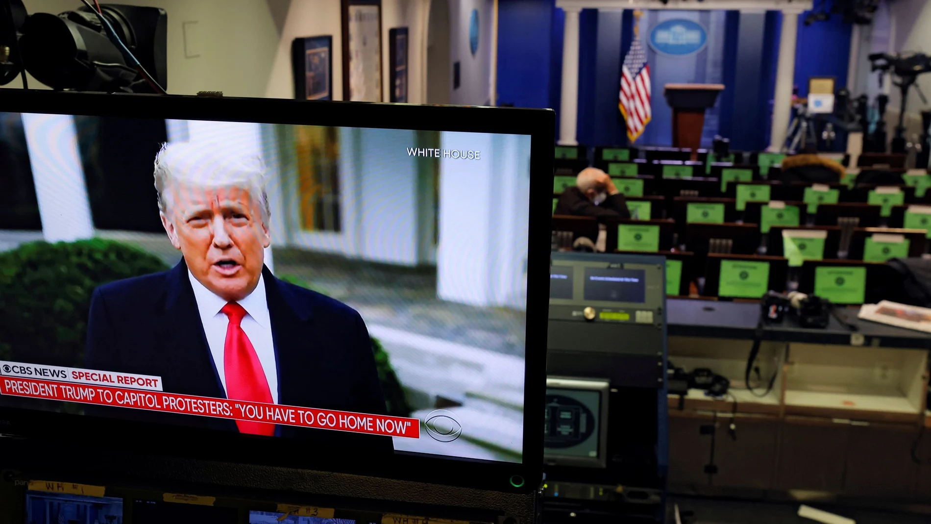 El presidente de EE UU, Donald Trump, aparece reflejado en una pantalla de televisión desde la Sala de Información de la Casa Blanca