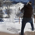 Un hombre quita nieve con una pala en la montaña leonesa