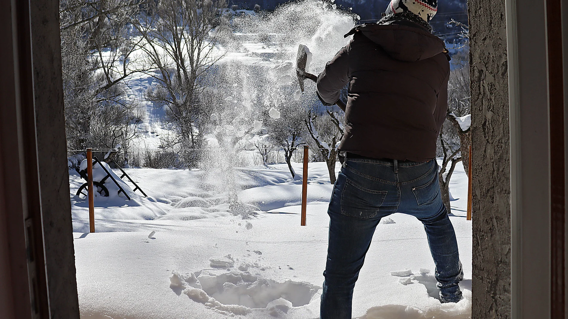 Un hombre quita nieve con una pala en la montaña leonesa