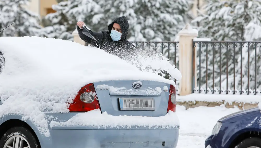Un hombre quita la nieve de su coche tras el paso de la borrasca Filomena en Teruel, en Aragón (España) a 8 de enero de 2021. Javier Escriche / Europa Press